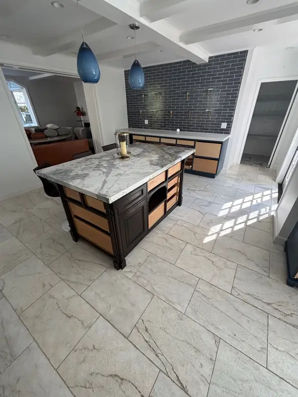 The kitchen before the refresh: dark cabinetry, espresso floors and a heavy stone island