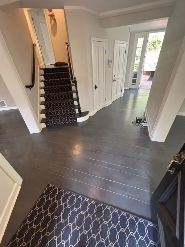 The entry and stair with dark floors before the refresh