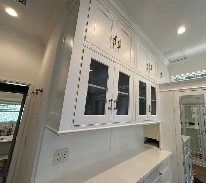 White custom closet millwork with glass-front uppers