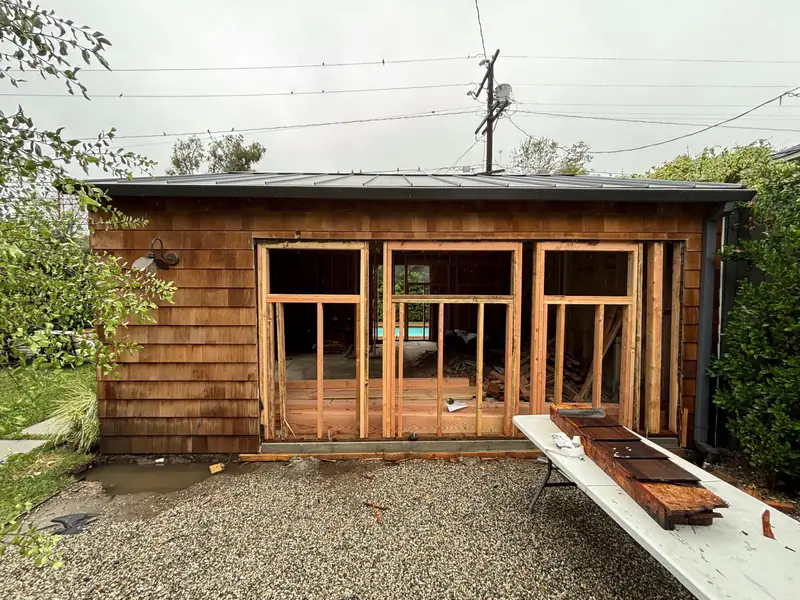 The original shingled garden room with its front wall opened up for new framing