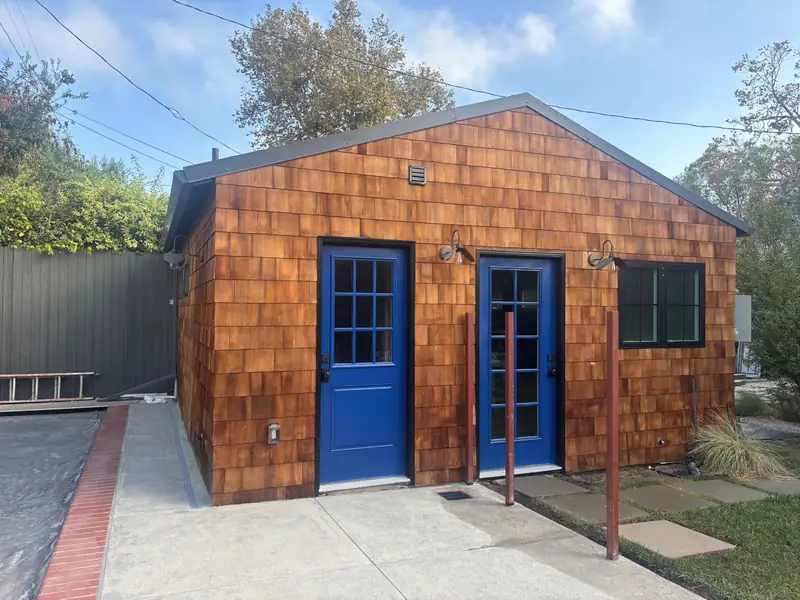 The finished studio with cobalt lacquered doors and cedar shingles