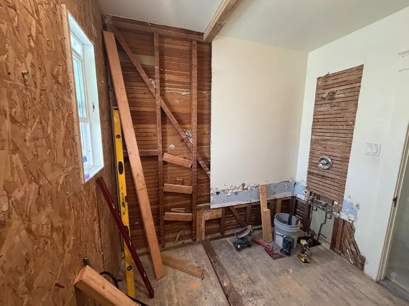 The shower wall opened to the studs and sheathing