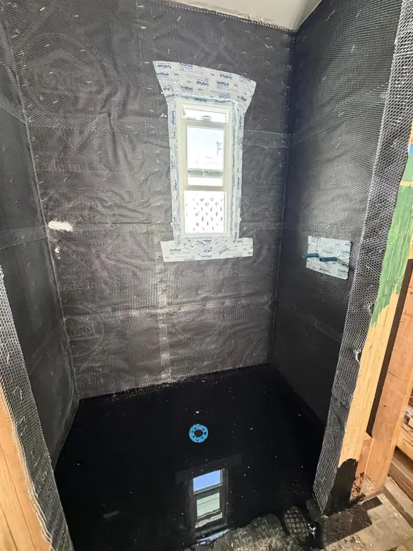 Shower walls wrapped in a waterproofing membrane around the window