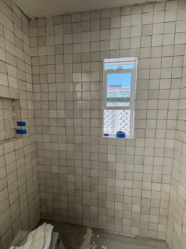 White zellige tile set on the shower walls with a recessed niche
