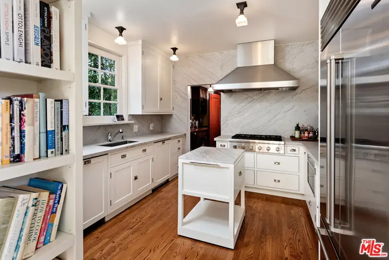 The original range wall with a stainless hood and a marble backsplash