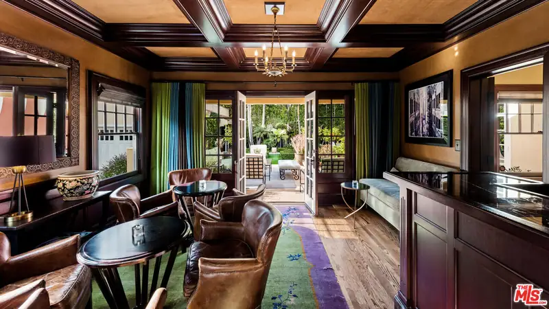 The dark-paneled den with a coffered ceiling, before it was opened up