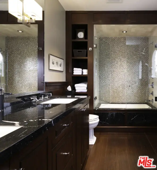 The original primary bath in black marble and dark wood