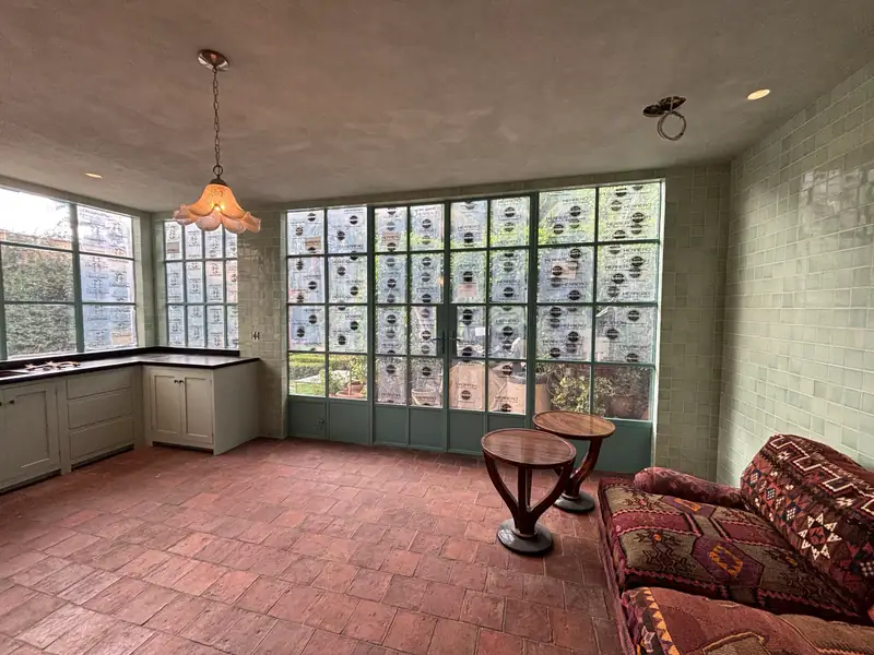 Room lined in glazed sage tile with new steel windows and doors