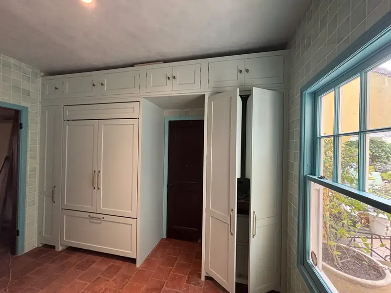 Paneled refrigerator and pantry wall in painted millwork
