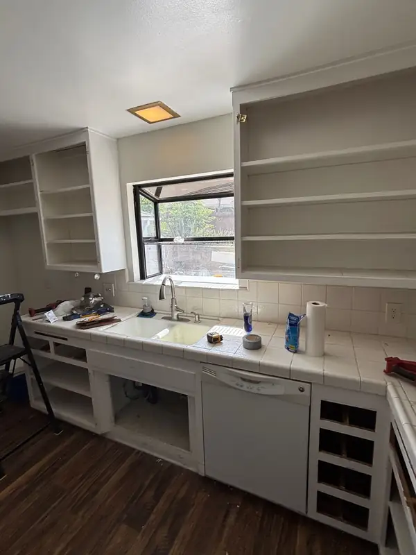 The original sink wall with white tile counters, just before demolition