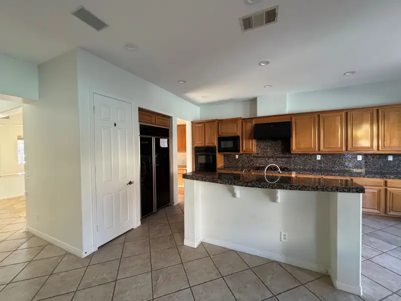The kitchen before the remodel: honey oak cabinets, granite counters and tile floors
