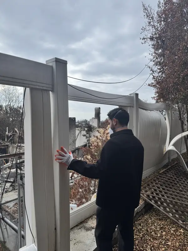 David Gaon walking the burned property after the fire, the fence line still standing