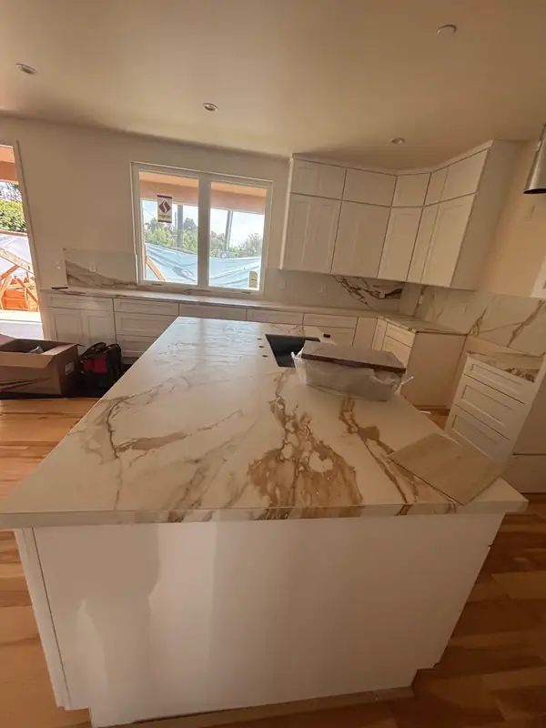 Book-matched slab counter with gold and grey veining being set on the island