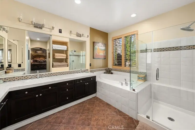 The primary bath before the remodel, with a drop-in tub and dark vanity