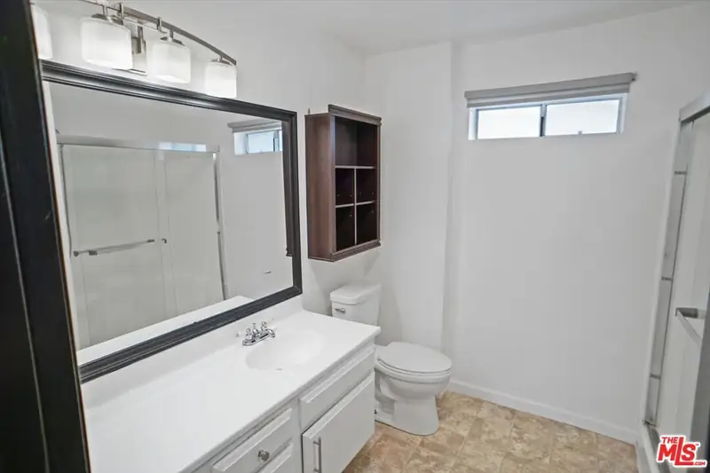 The original bath with a basic vanity and a tub-shower combination