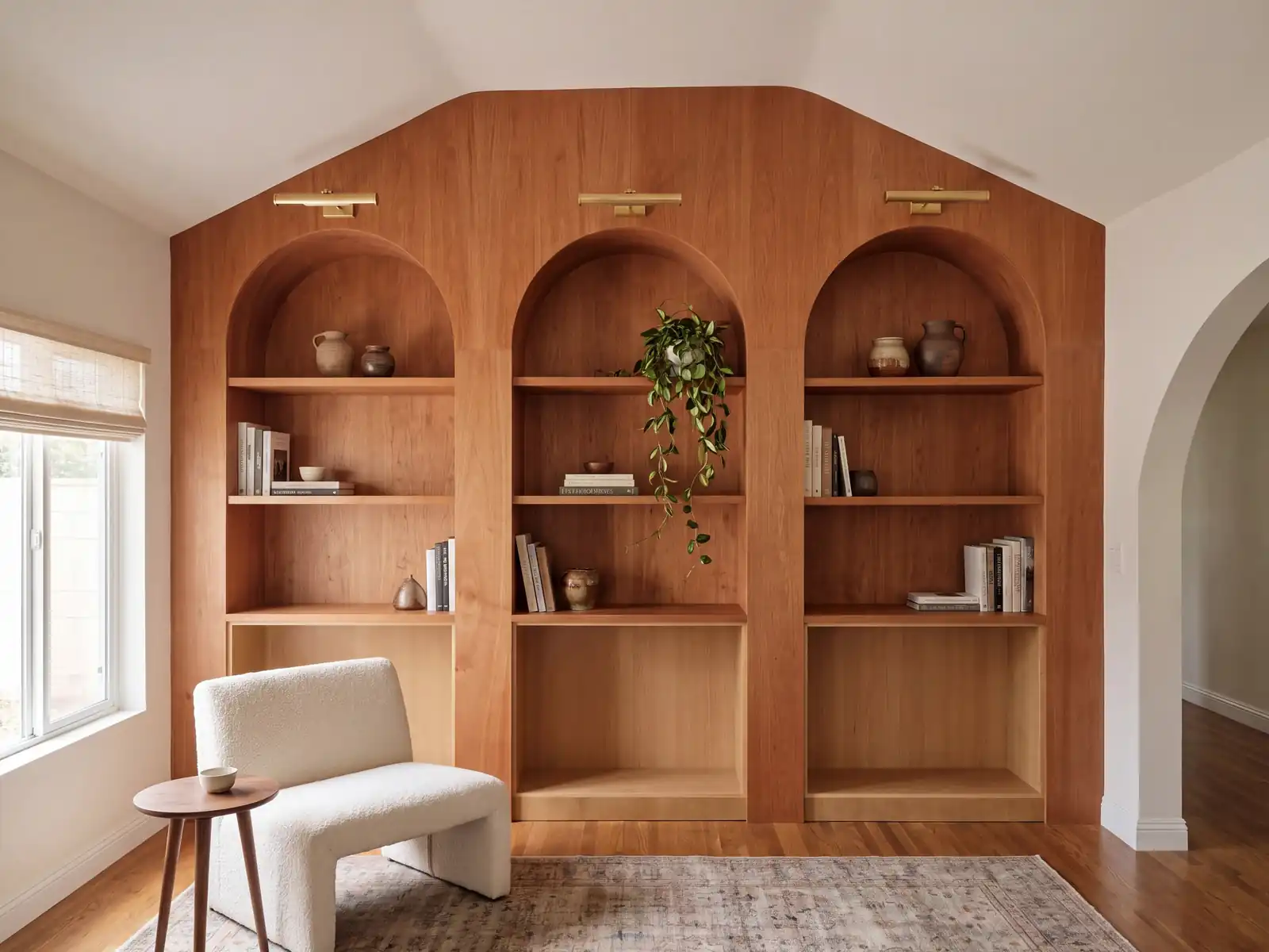 The same cherry built-in wall styled, with brass picture lights, books and ceramics
