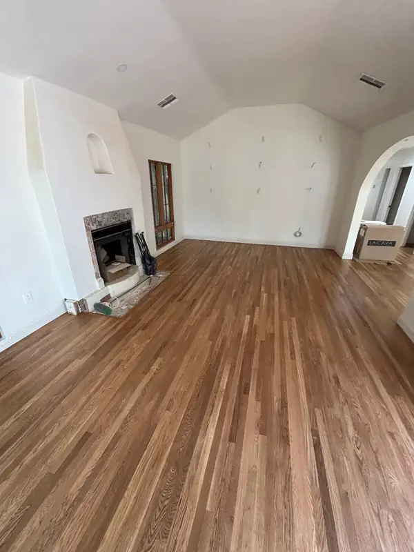 Living room with refinished oak floors and the fireplace ready for its plaster surround