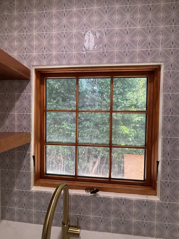Stained wood window casing set in patterned wall tile