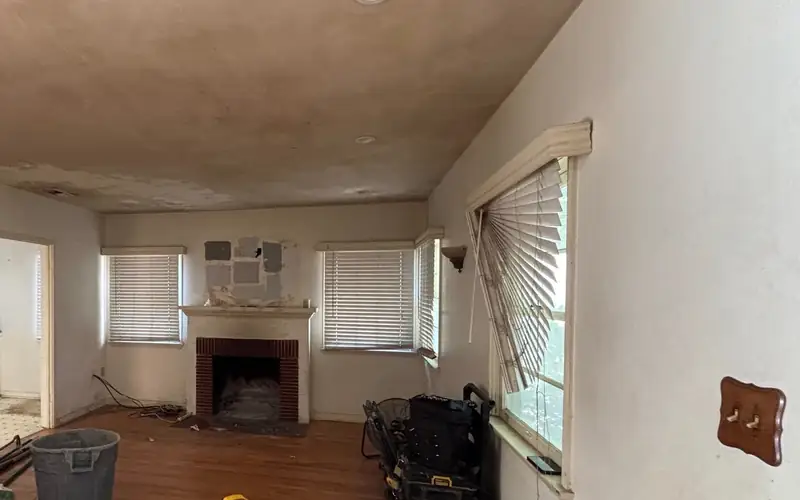 Living room of the original house before teardown, with a brick fireplace