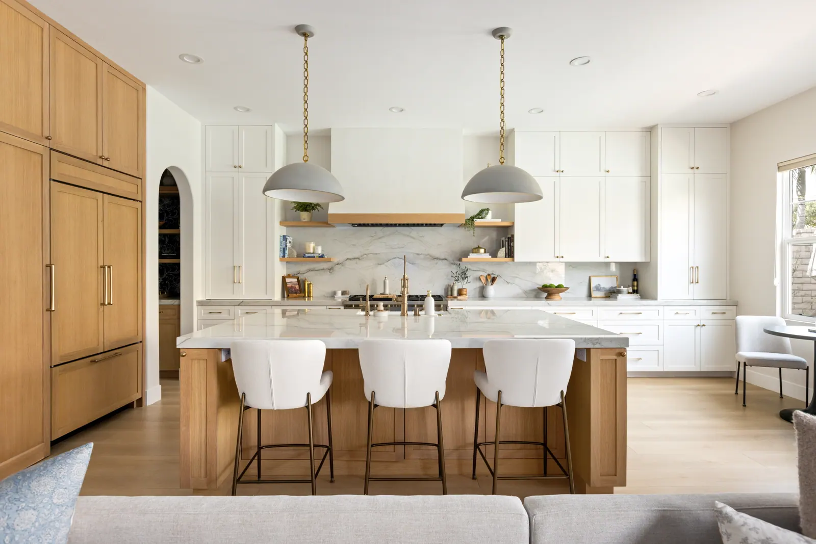 Open-plan kitchen with a white oak island and marble counters