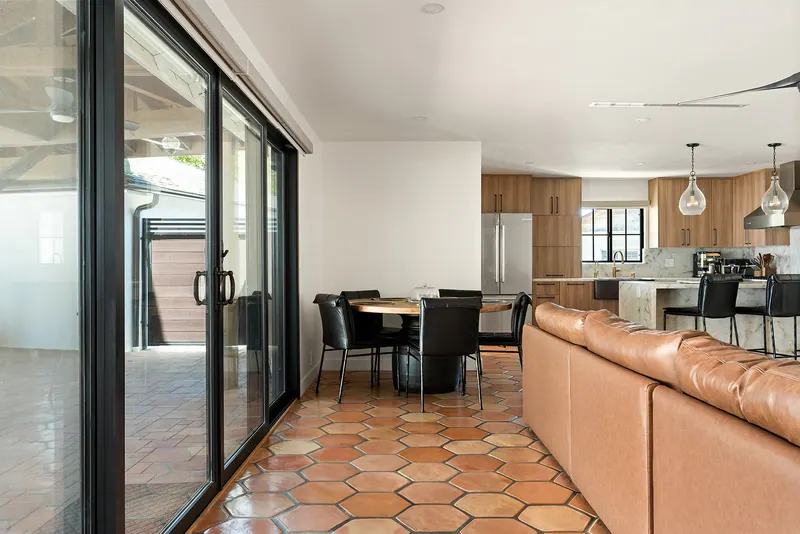Great room with sliding glass doors, dining table and the kitchen beyond