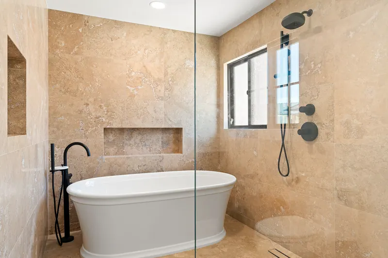 Primary bath with a freestanding tub, matte black tub filler and walk-in shower