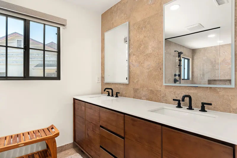 Double vanity in walnut-tone wood with matte black faucets