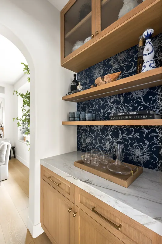 Bar niche with glass-front oak uppers and a patterned blue backdrop