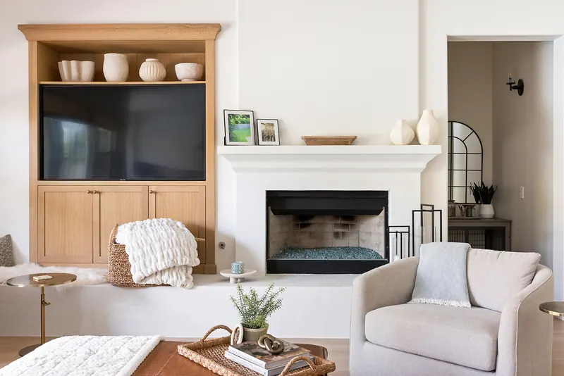 Living room with white oak built-ins around a plaster fireplace