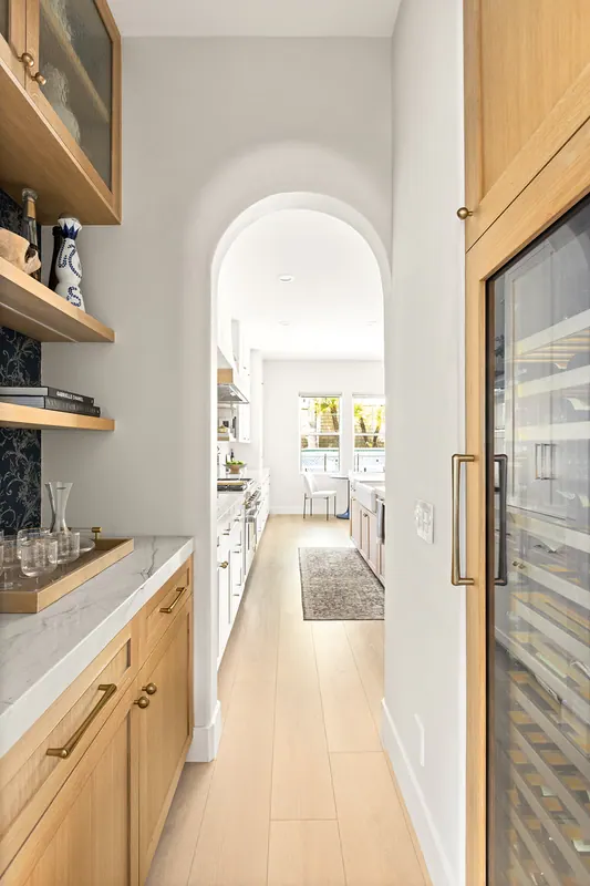 Arched hall with oak cabinetry and a built-in beverage refrigerator