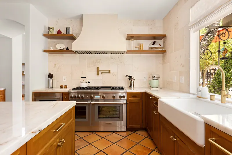 Professional range under a plaster hood with floating wood shelves